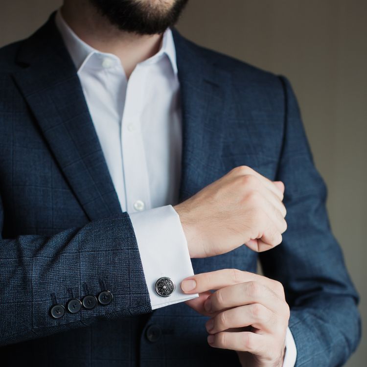 Jewelry like leather bracelets, metal watches, and engraved cufflinks infuse tailored ensembles with personality.